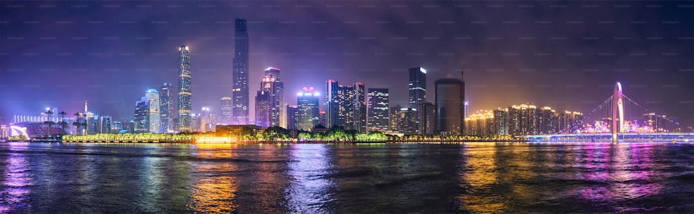 La ligne d’horizon du paysage urbain de Guangzhou au-dessus de la rivière des Perles avec le pont Liede illuminé le soir. Guangzhou, Chine