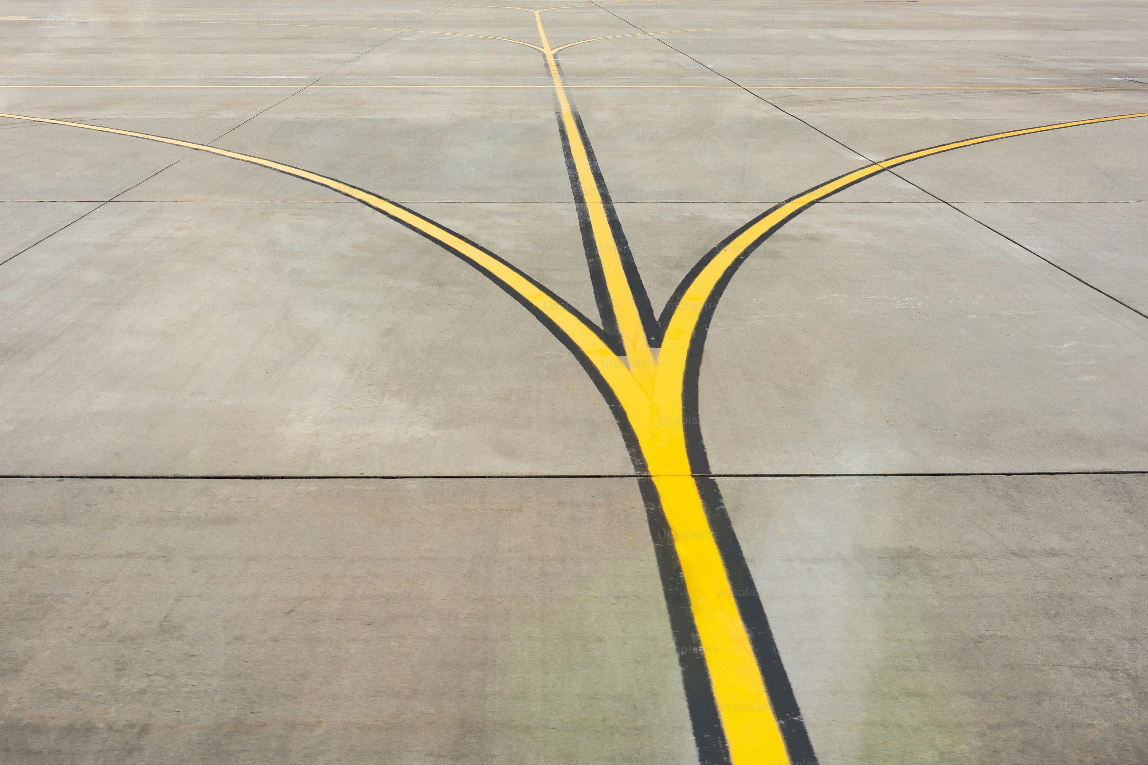 Yellow direction strips fork close up on an airfield runway