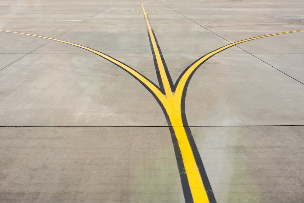 Garfo de tiras de direção amarelas perto de uma pista de aeródromo