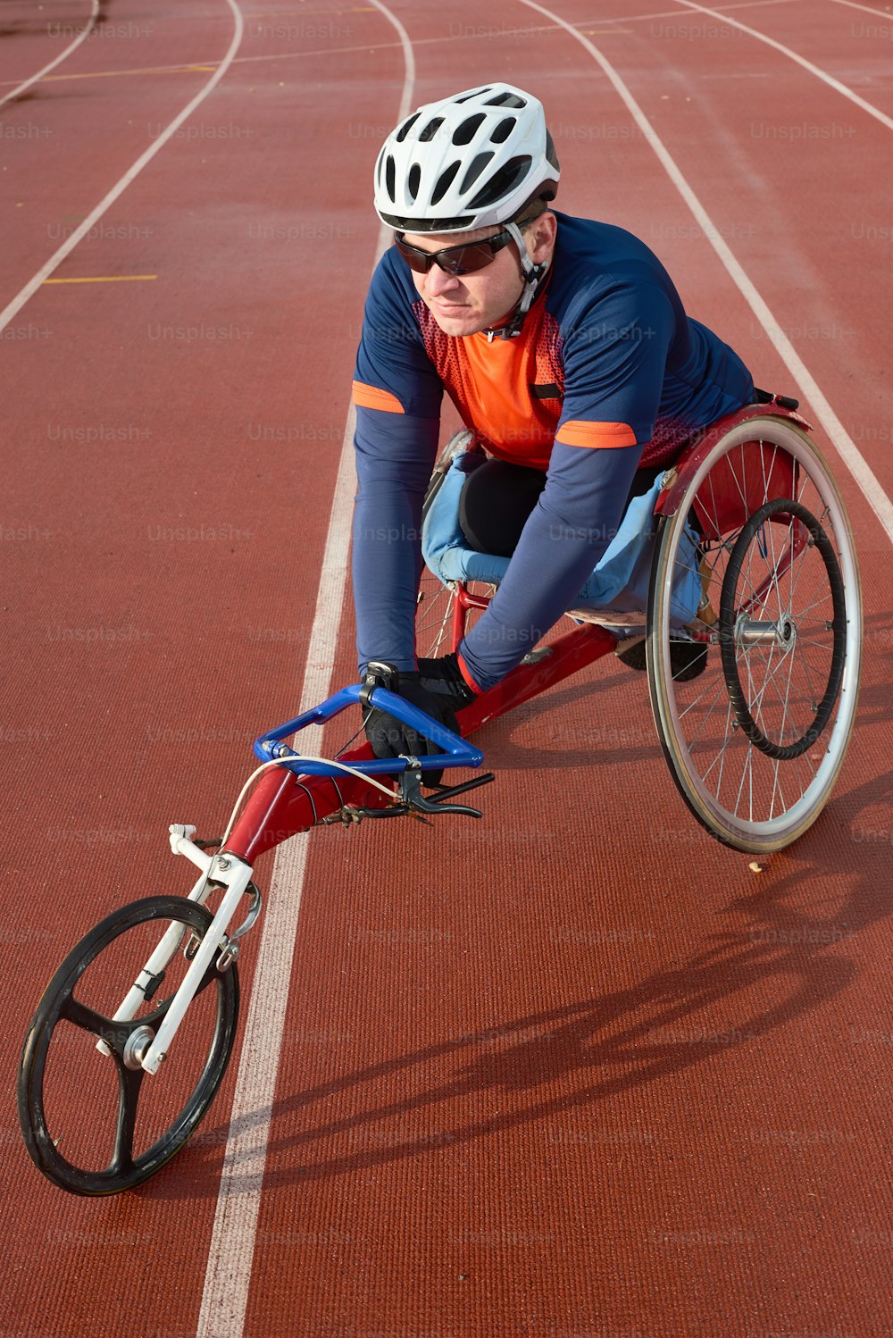Future Paralympic champion. Disabled male athlete in sportswear and helmet sitting in racing wheelchair and concentrating before competing on track