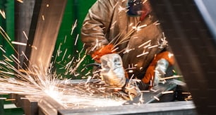 Metalworker working with angle grinder, lots of sparks flying