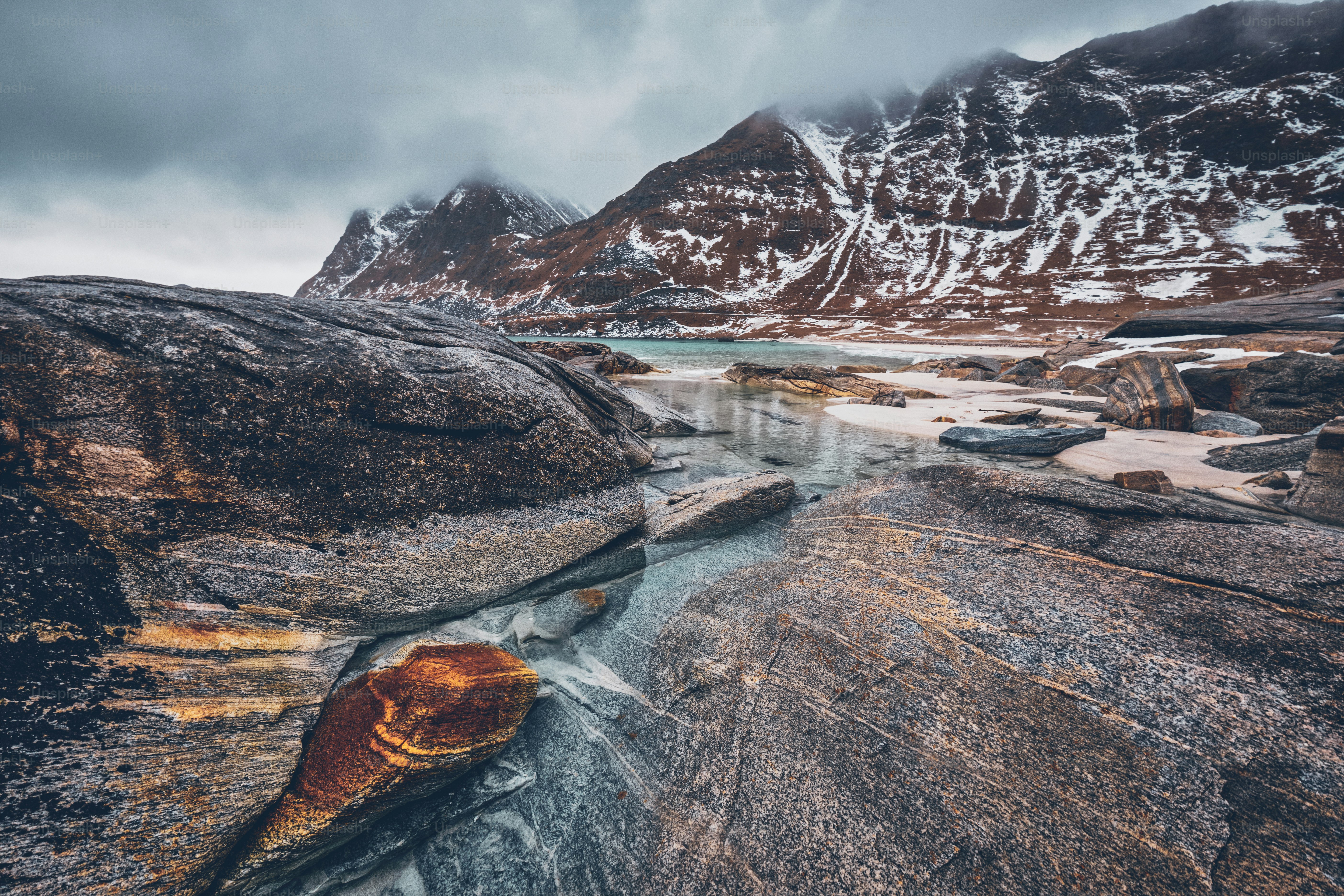 Rocky coast of fjord of Norwegian sea in winter with snow. Haukland beach, Lofoten islands, Norway