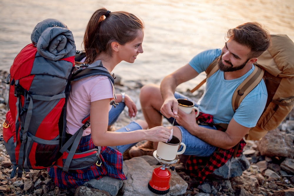 Mountaineers make tea outside on the break. Travel, people and lifestyle concept.