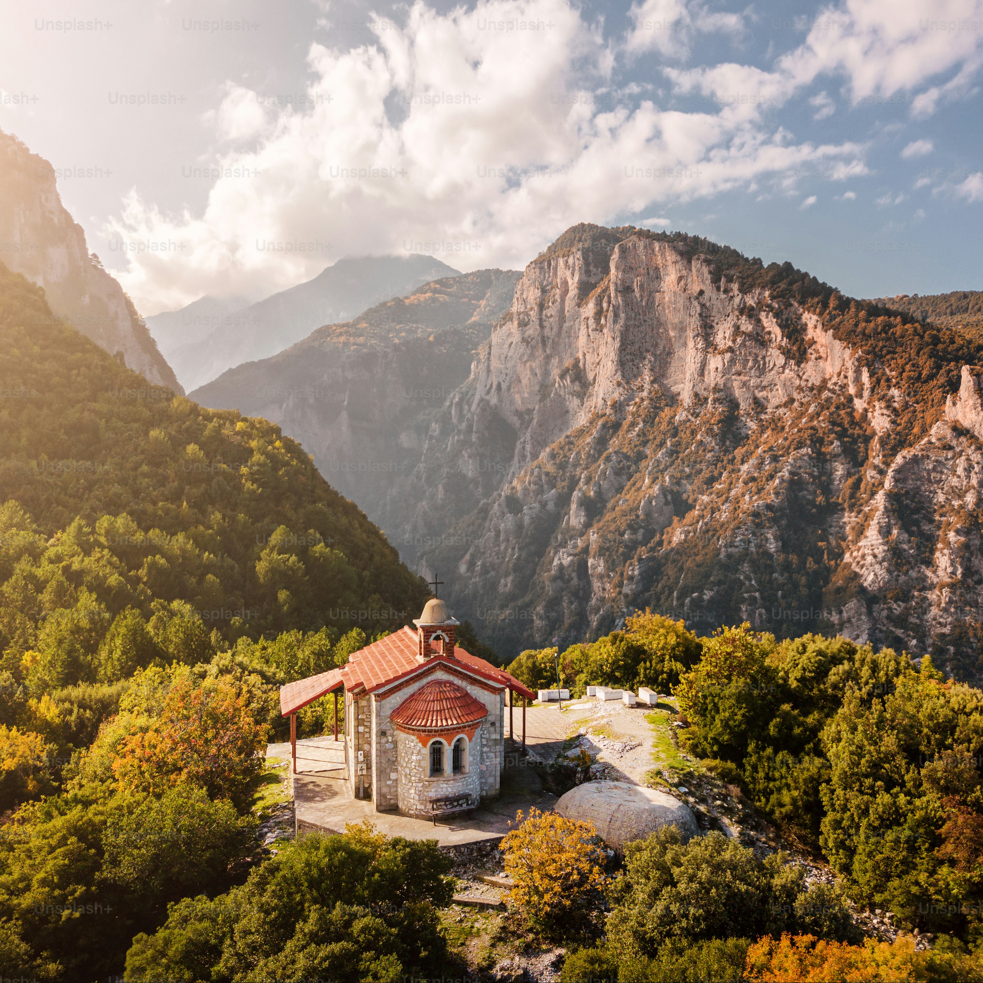 Aerial drone panoramic view of a little church on a cliff in deep canyon near legendary Mountain Olympus - the pantheon of all Greek gods and Great Zeus. National Parks in Greece