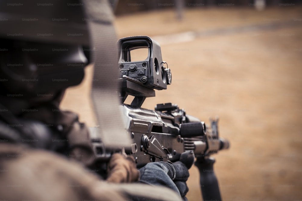 Imagem de um soldado apontando para uma mira de colimador. O conceito de conflitos militares. Mídia mista