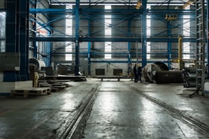 Two workers planning manufacturing process in the interior of an industrial hall