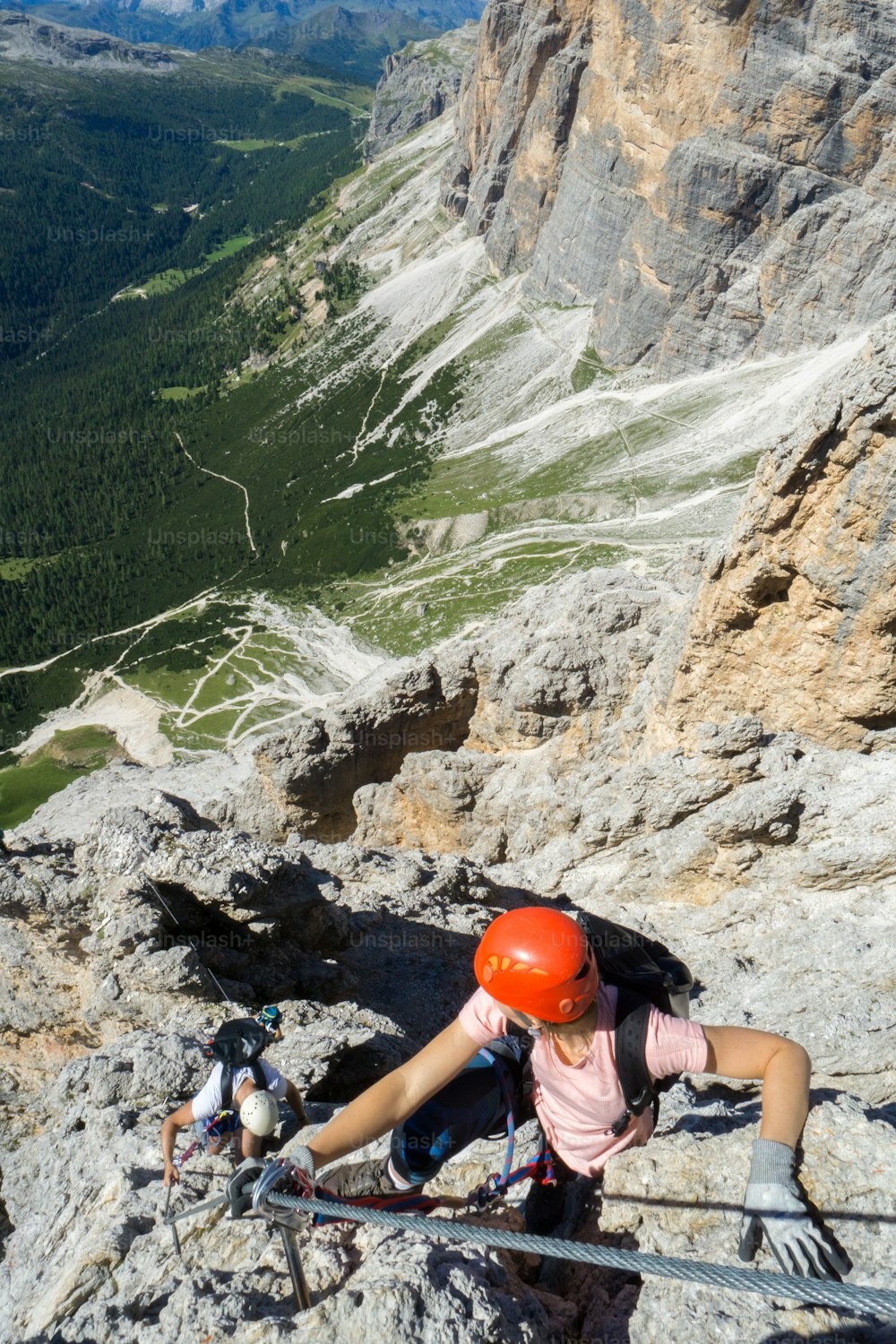 several young mountain climbers on very exposed Via Ferrata in Alta Badia in the Italian Dolomites