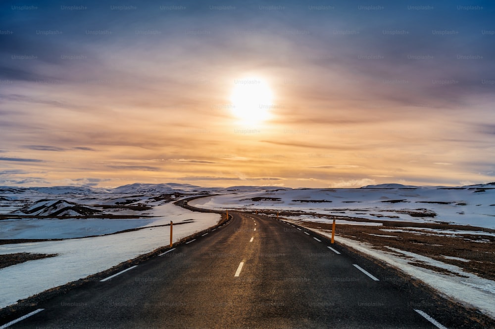 Uma longa estrada reta ao pôr do sol no inverno.