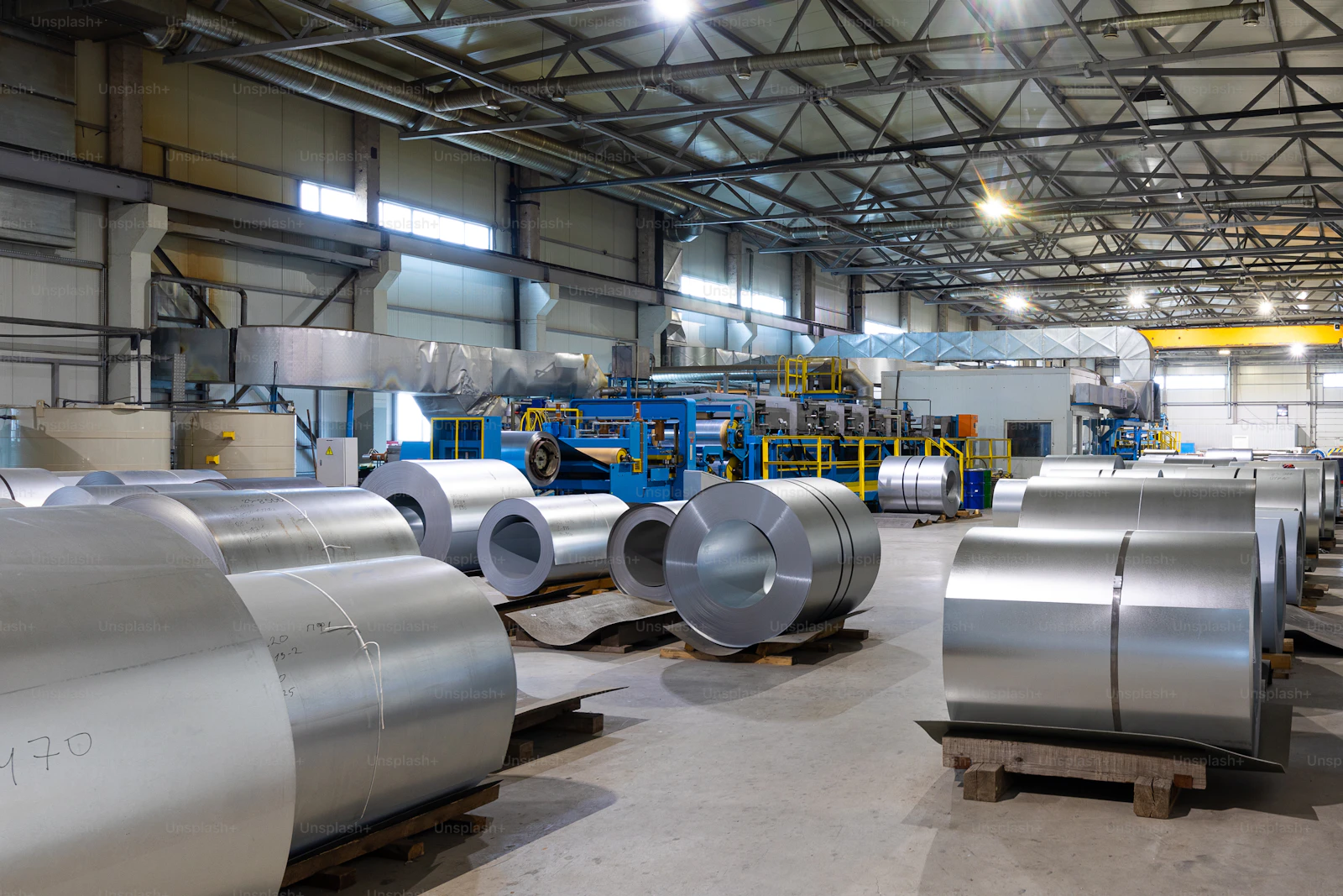Industrial steel coils stacked in a manufacturing facility ready for processing