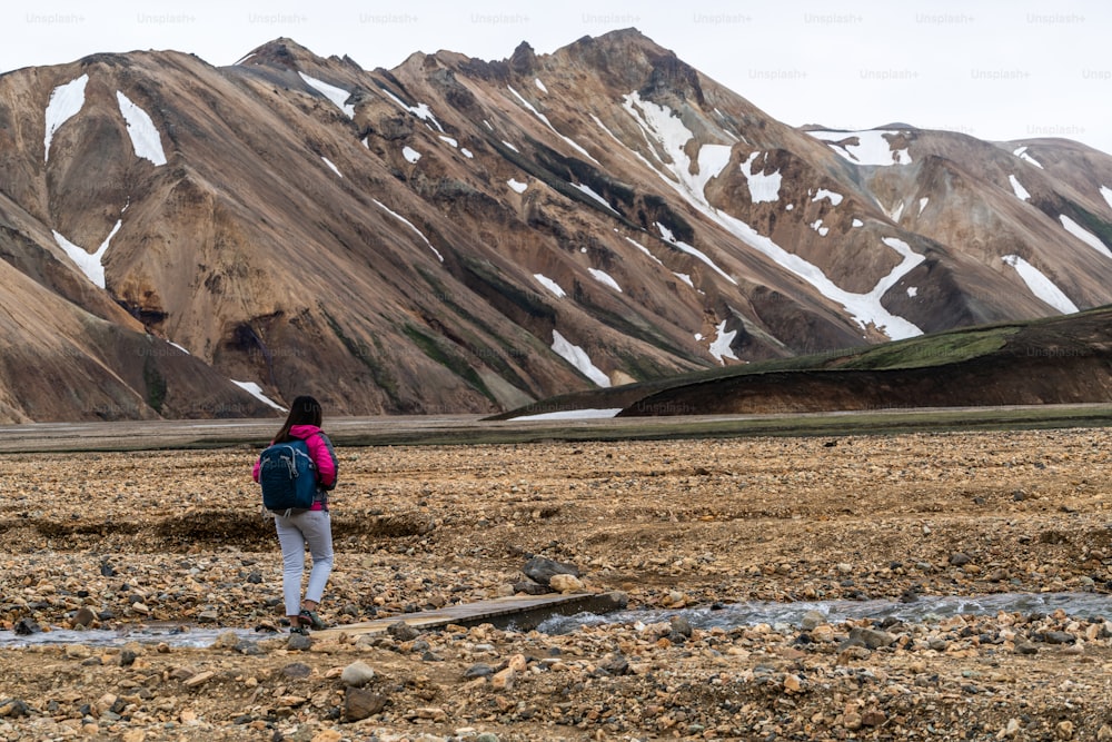 アイスランド、北欧、ヨーロッパの高地にあるLandmannalaugarシュールな自然の風景でハイキングする旅行者。夏のトレッキングアドベンチャーやアウトドアウォーキングで有名な美しいカラフルな雪山の地形。