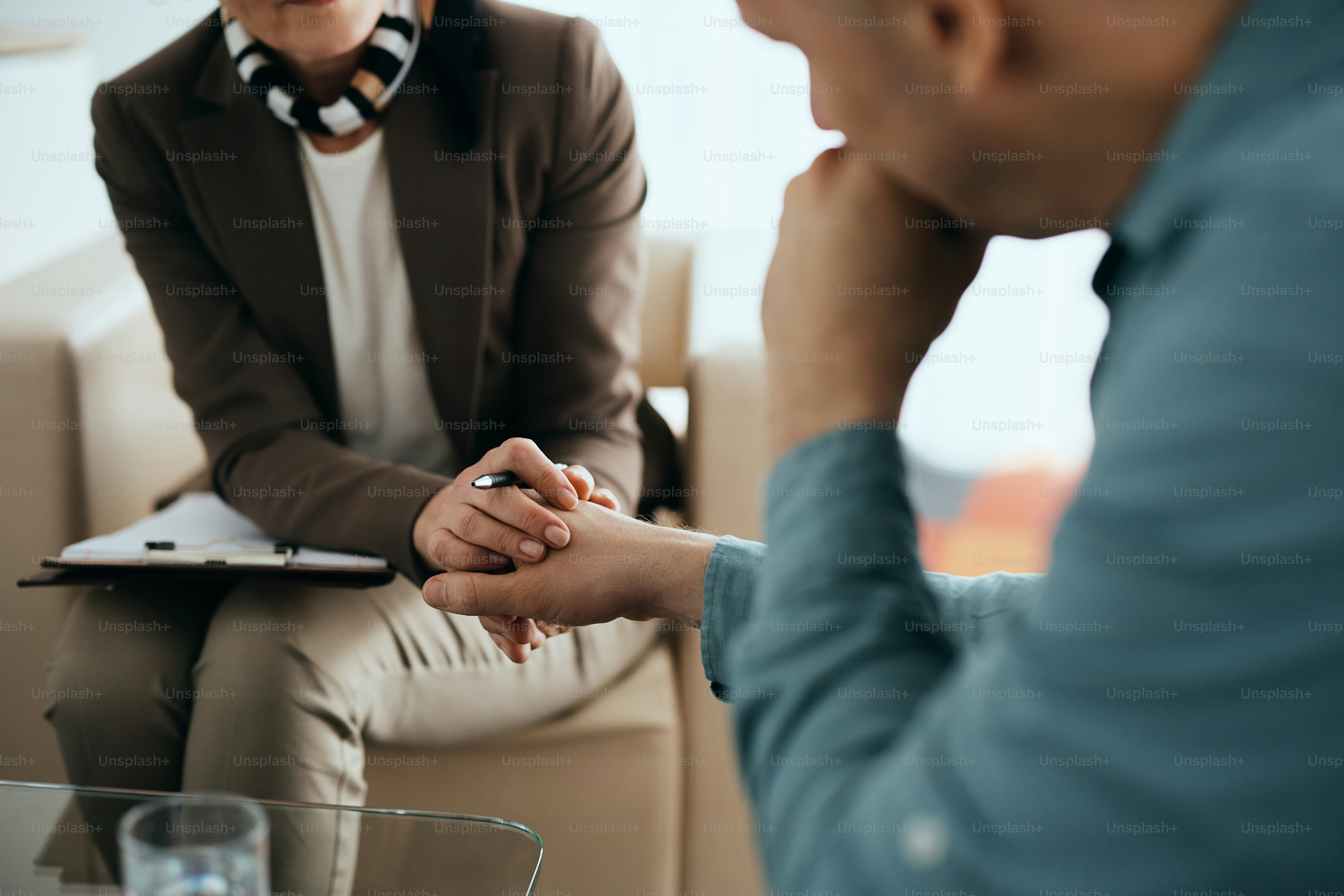 Nahaufnahme der fürsorglichen Therapeutin, die während der psychologischen Beratung Händchen hält.