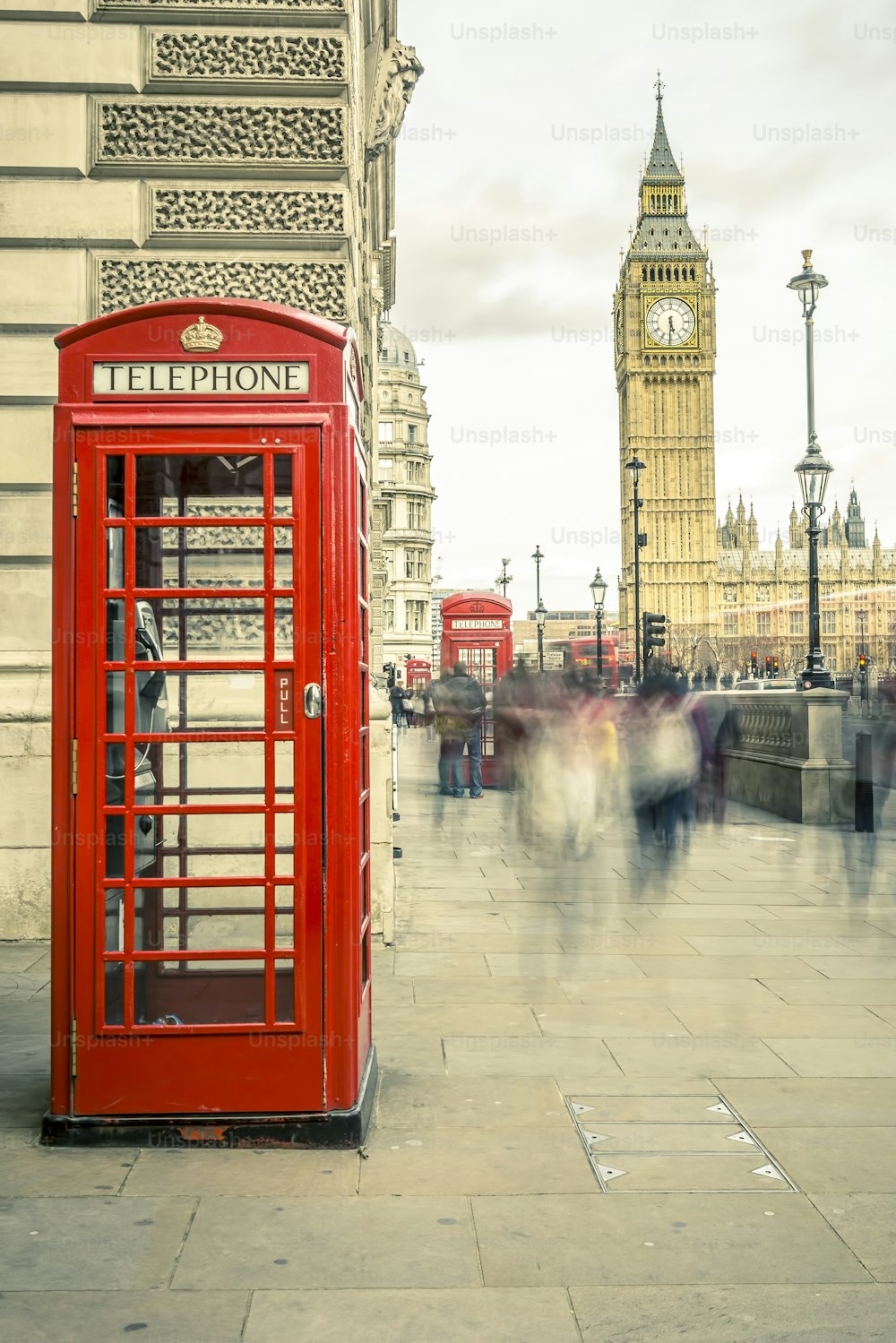ロンドンの中心部にあるビッグベンを背景にした象徴的な英国の古い赤い電話ボックス