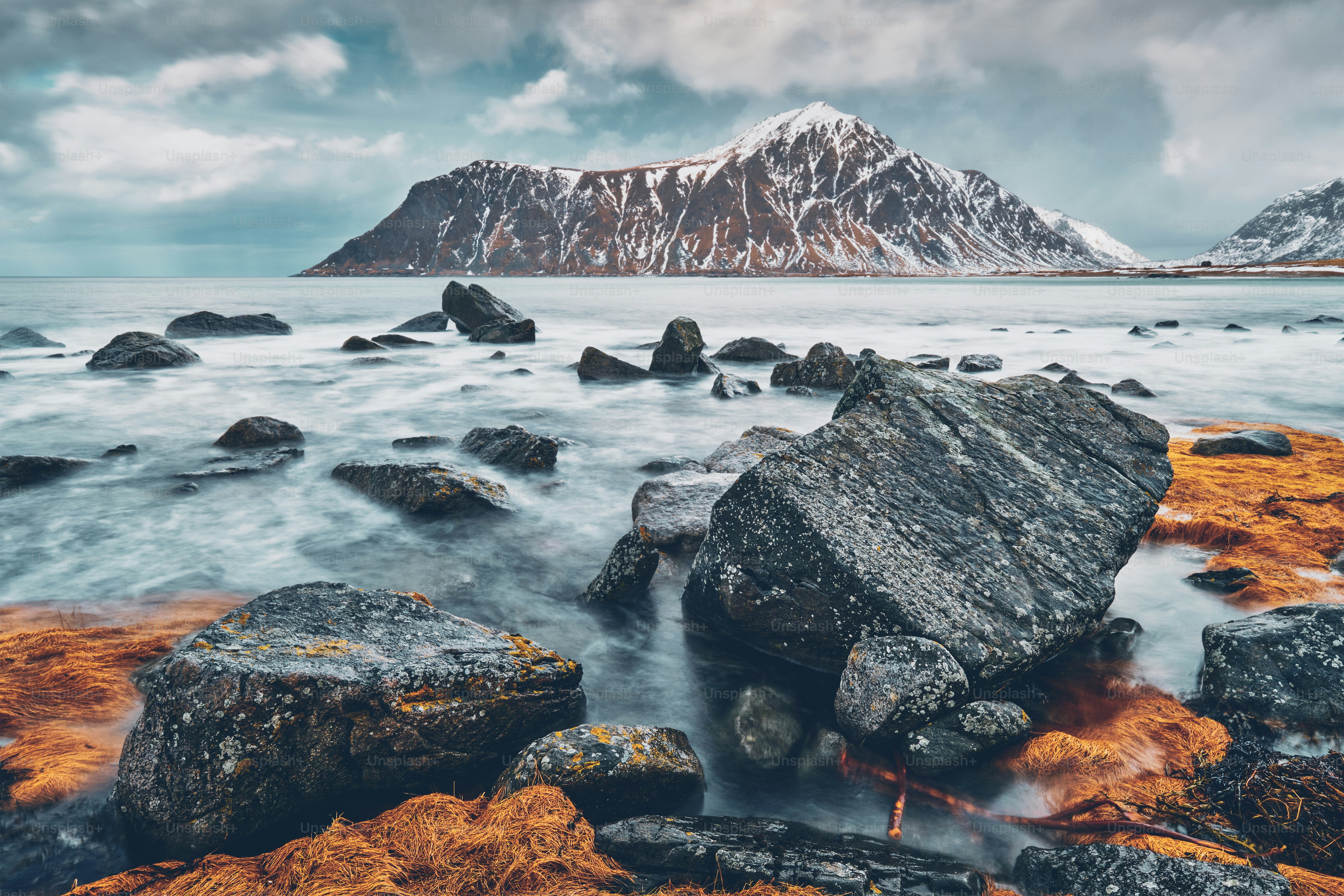 Rocky coast of fjord of Norwegian sea in winter with snow. Skagsanden beach, Lofoten islands, Norway