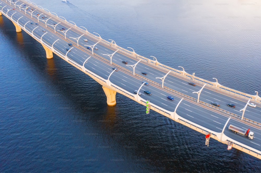 High-speed highway, turn traffic road, the bridge across over the bay sea river. Aerial top view