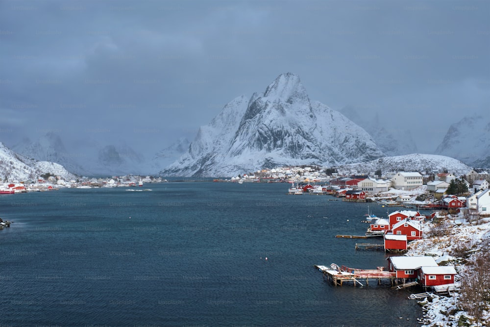 Villaggio di pescatori di Reine sulle isole Lofoten con case rorbu rosse in inverno con neve. Norvegia