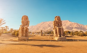 멤논의 유명한 두 거상 - 파라오 아멘호텝 3세의 거대한 폐허가 된 동상. 룩소르 인근의 여행 및 관광 명소
