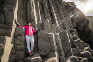 Il viaggiatore viaggia verso una formazione rocciosa vulcanica unica sulla spiaggia di sabbia nera dell'Islanda situata vicino al villaggio di Vik i myrdalin, nel sud dell'Islanda. Le rocce colonnari esagonali attirano i turisti che visitano l'Islanda.