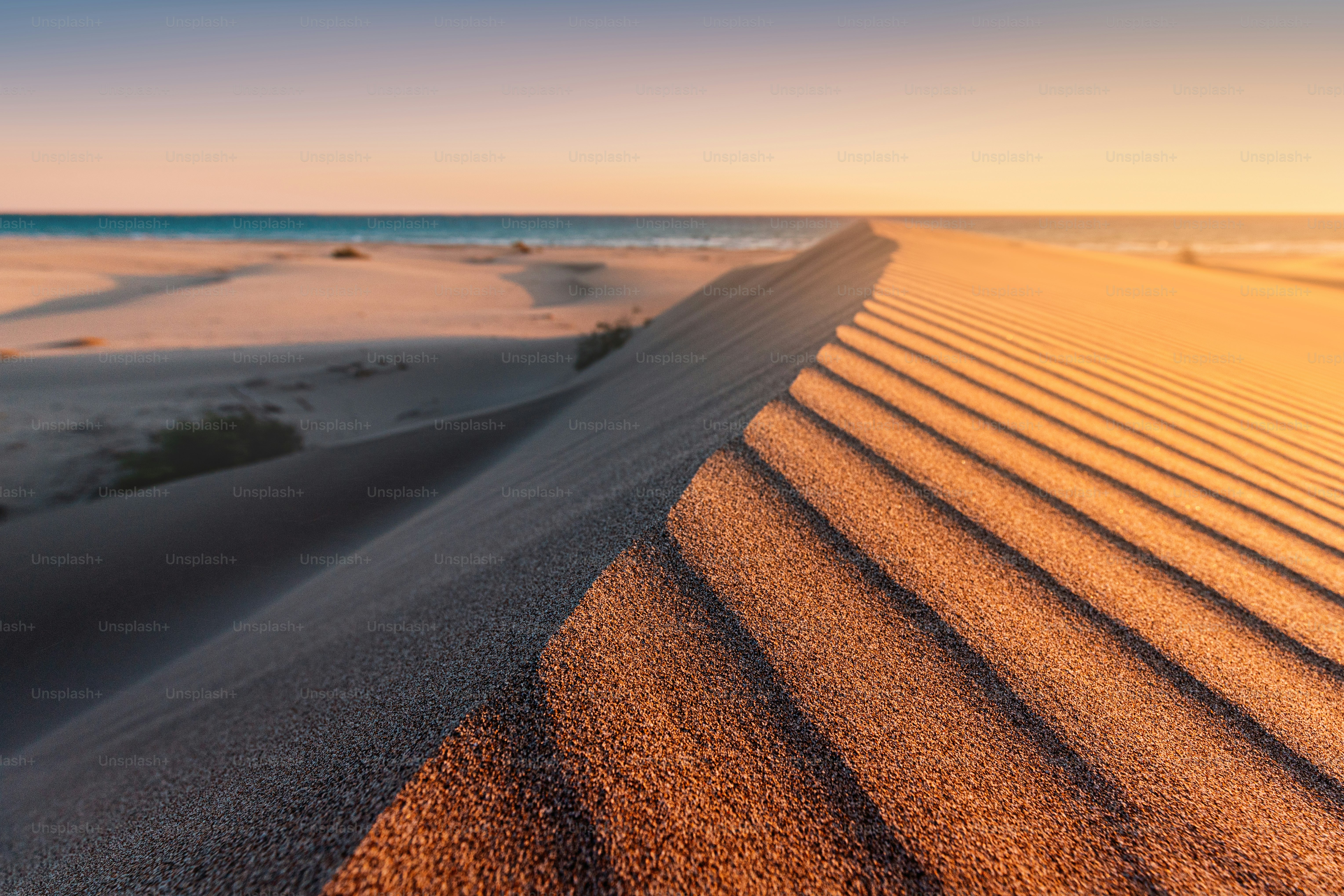 La plage de Patara est un célèbre site touristique et une destination naturelle en Turquie. Vue majestueuse sur les dunes de sable orange et les collines brille dans les rayons du coucher de soleil chaud.