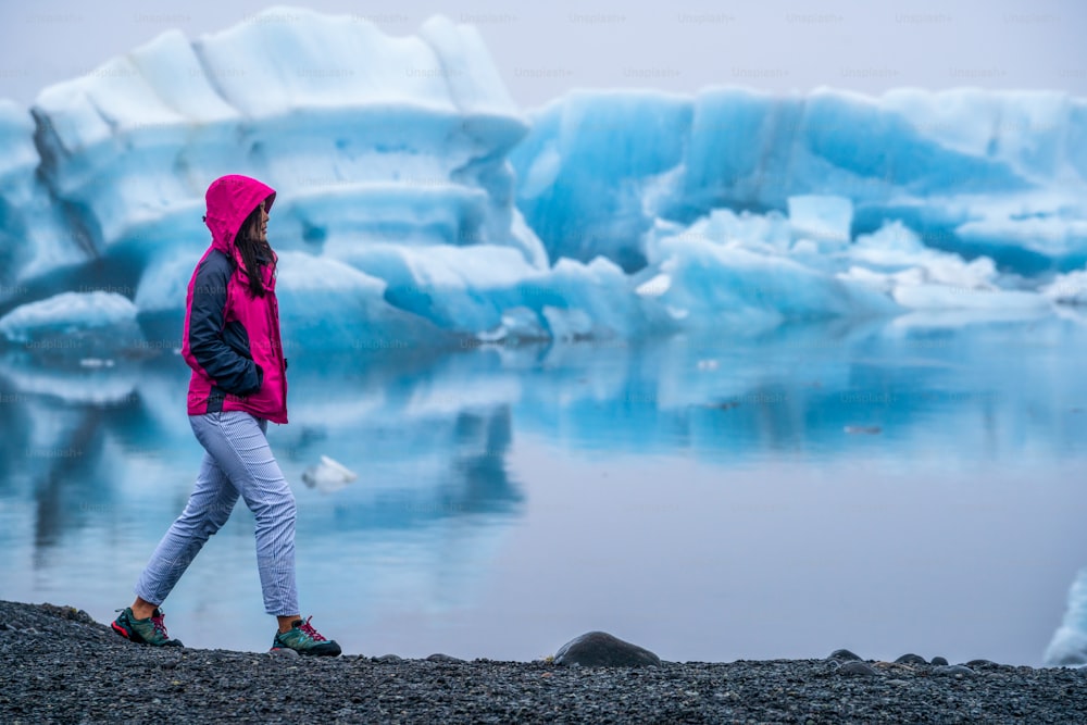 Weibliche Reisende reist nach Jokulsarlon schöne Gletscherlagune in Island. Jokulsarlon ist ein berühmtes Reiseziel im Vatnajökull-Nationalpark im Südosten Islands, Europa. Kaltes Wintereis Natur.