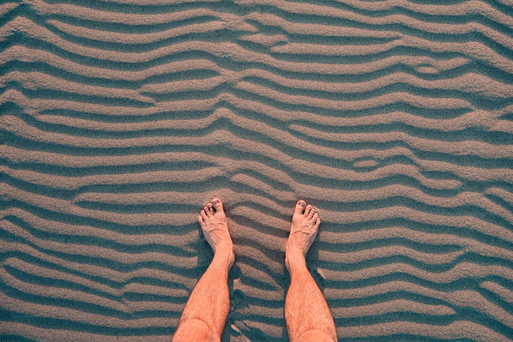 The traveler relaxes and rests with his bare feet on the warm sand. The concept of the hikes and the problems with orthopedics such as flat feet