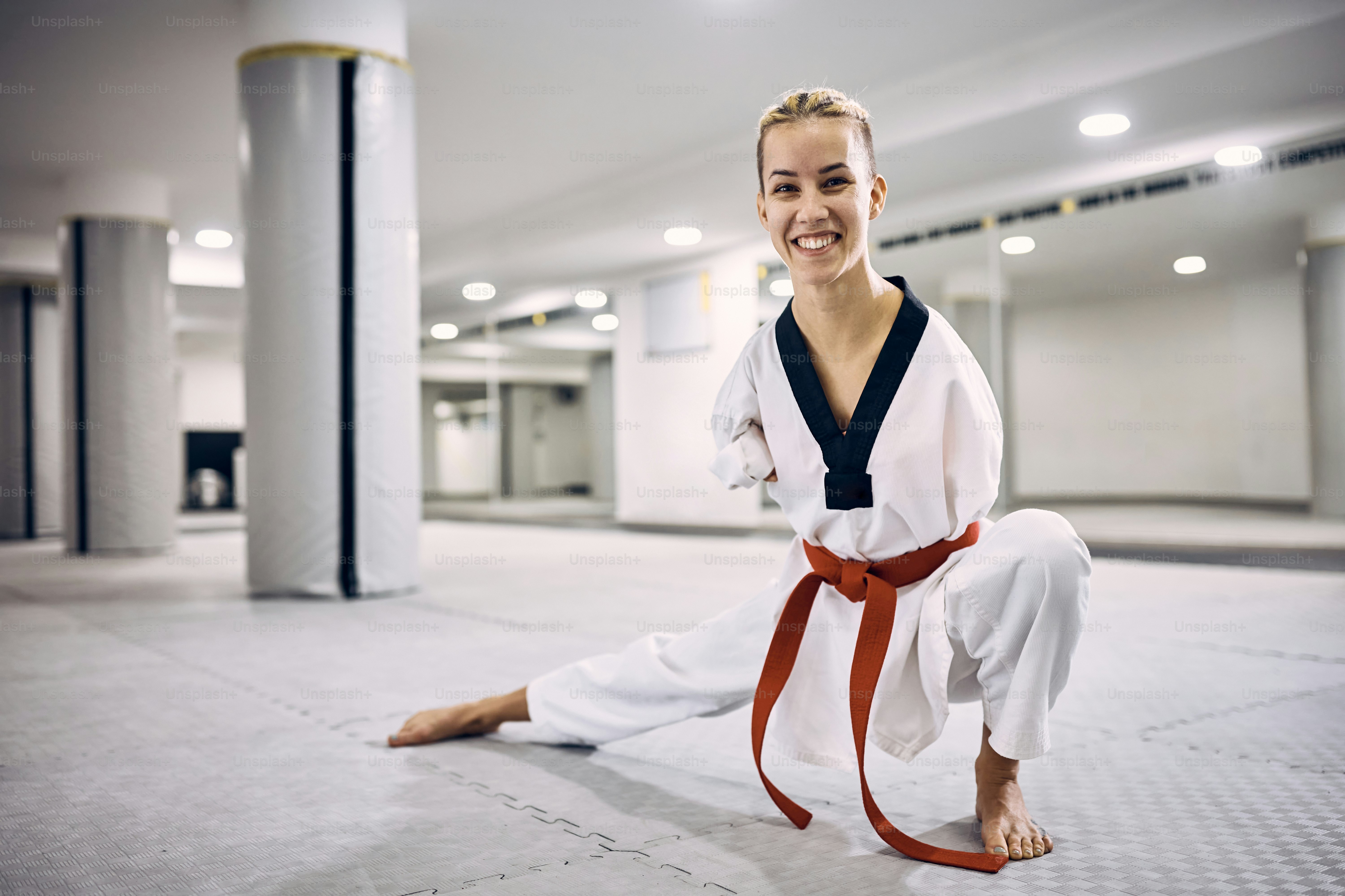 Motivated female taekwondo fighter with paraability warming up during