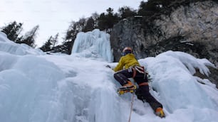 Un alpiniste se dirige vers la dernière longueur d’une longue et raide cascade de glace dans les Alpes suisses à Saint-Moritz après une dure journée d’escalade sur glace