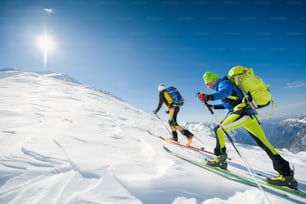 Squadra di sci di fondo coppia di uomini verso la vetta della montagna.