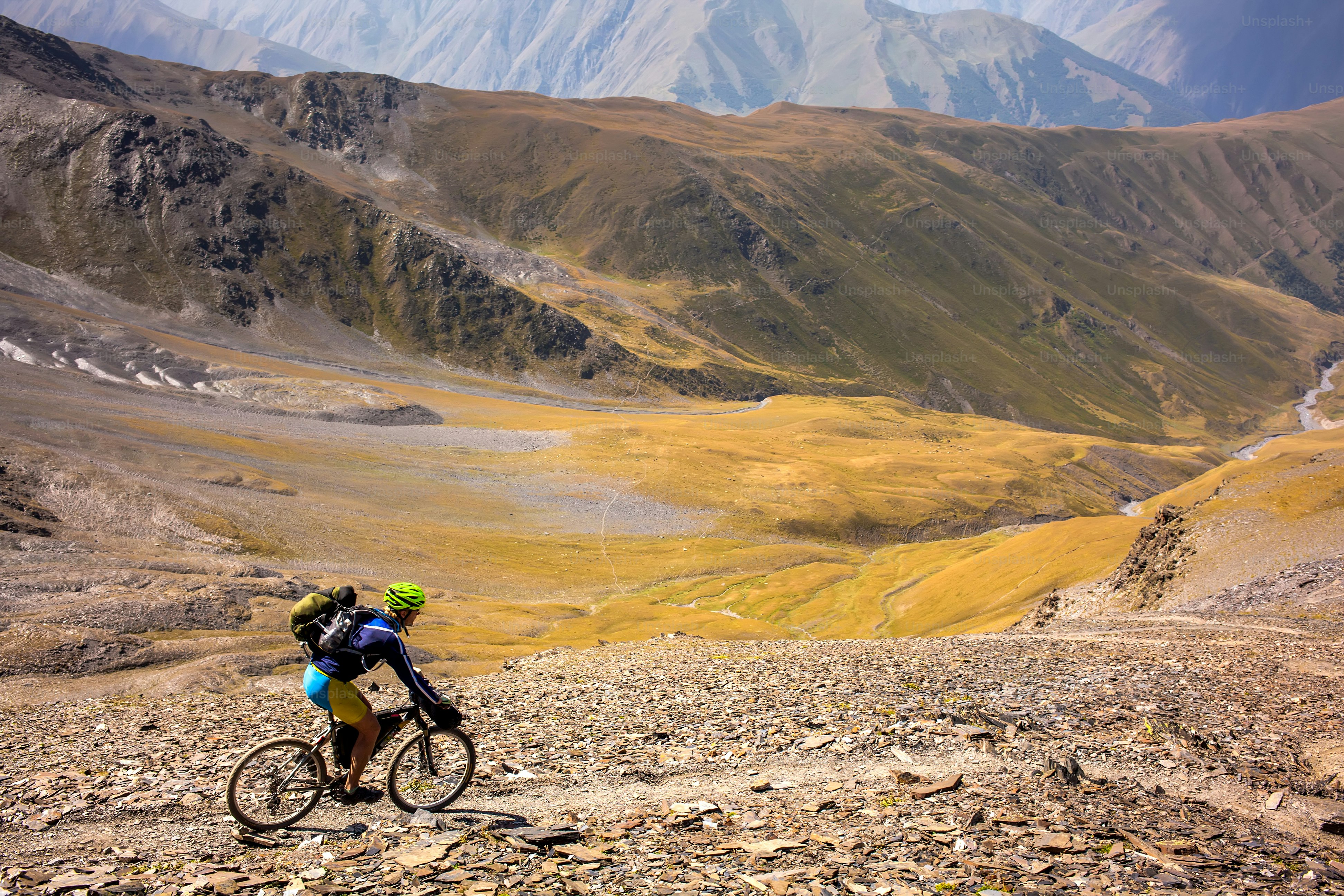man riding bike through moutains