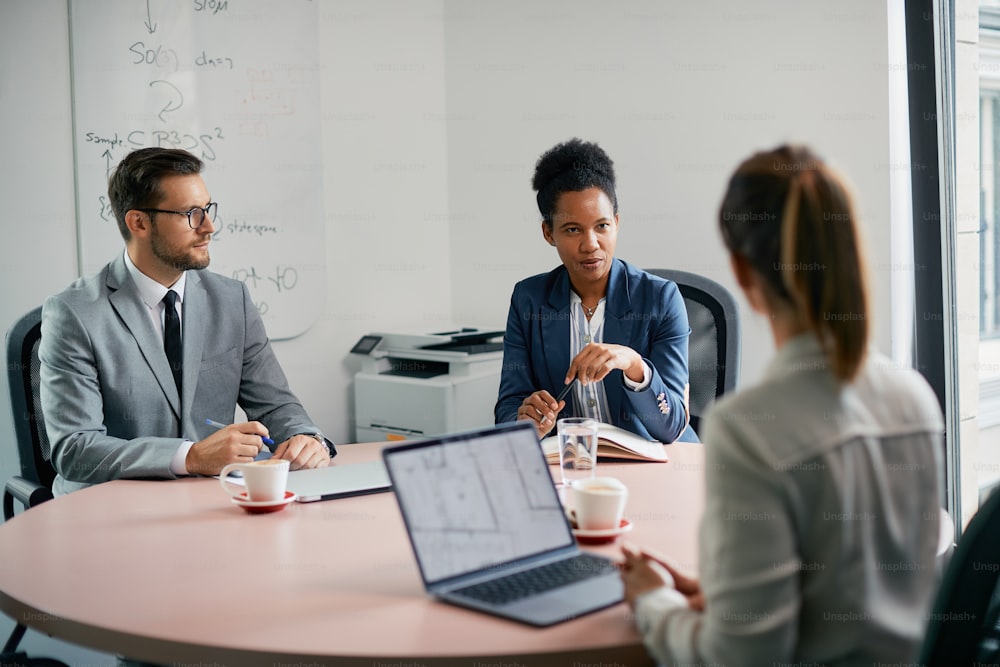 African American businesswoman communicating with her colleagues during a meeting in the office.