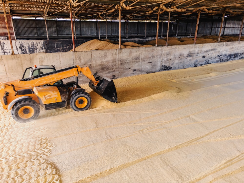 Barn full of corn. There is a vehicle in the corner.