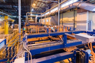 Interno dell'officina della fabbrica e macchine sul processo di produzione di fondo dell'industria del vetro