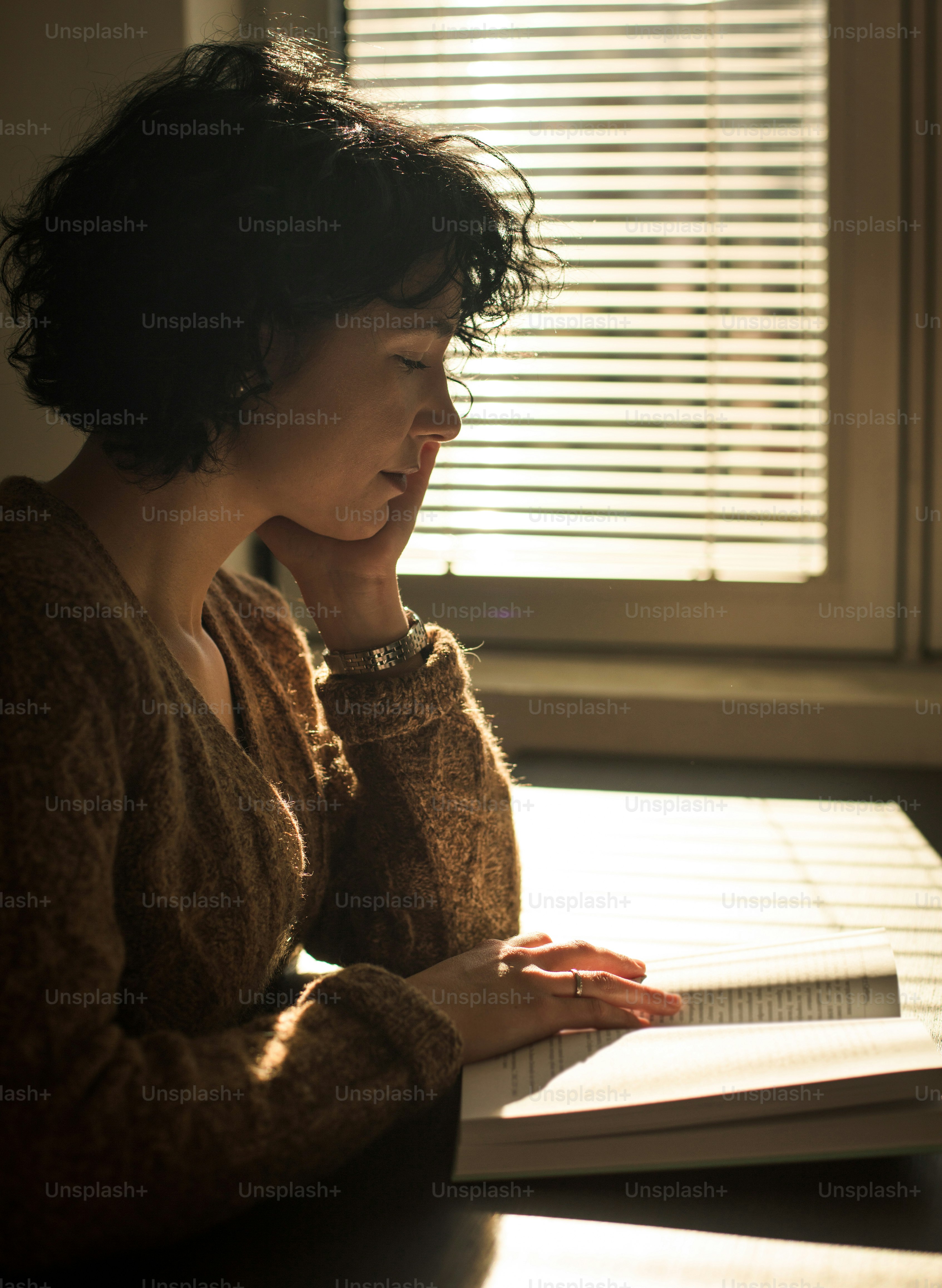 Mujer en la biblioteca leyendo un libro.