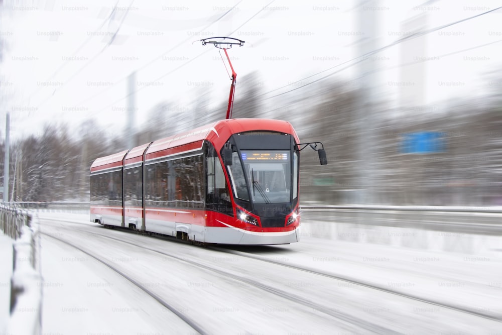 Die Straßenbahn fährt rasant an einer Kurve in einem schneebedeckten Stadtpark vorbei