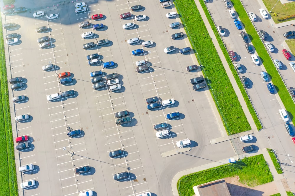 Aerial top down view of the parking lot with many cars of supermarket shoppers in the city grocery store