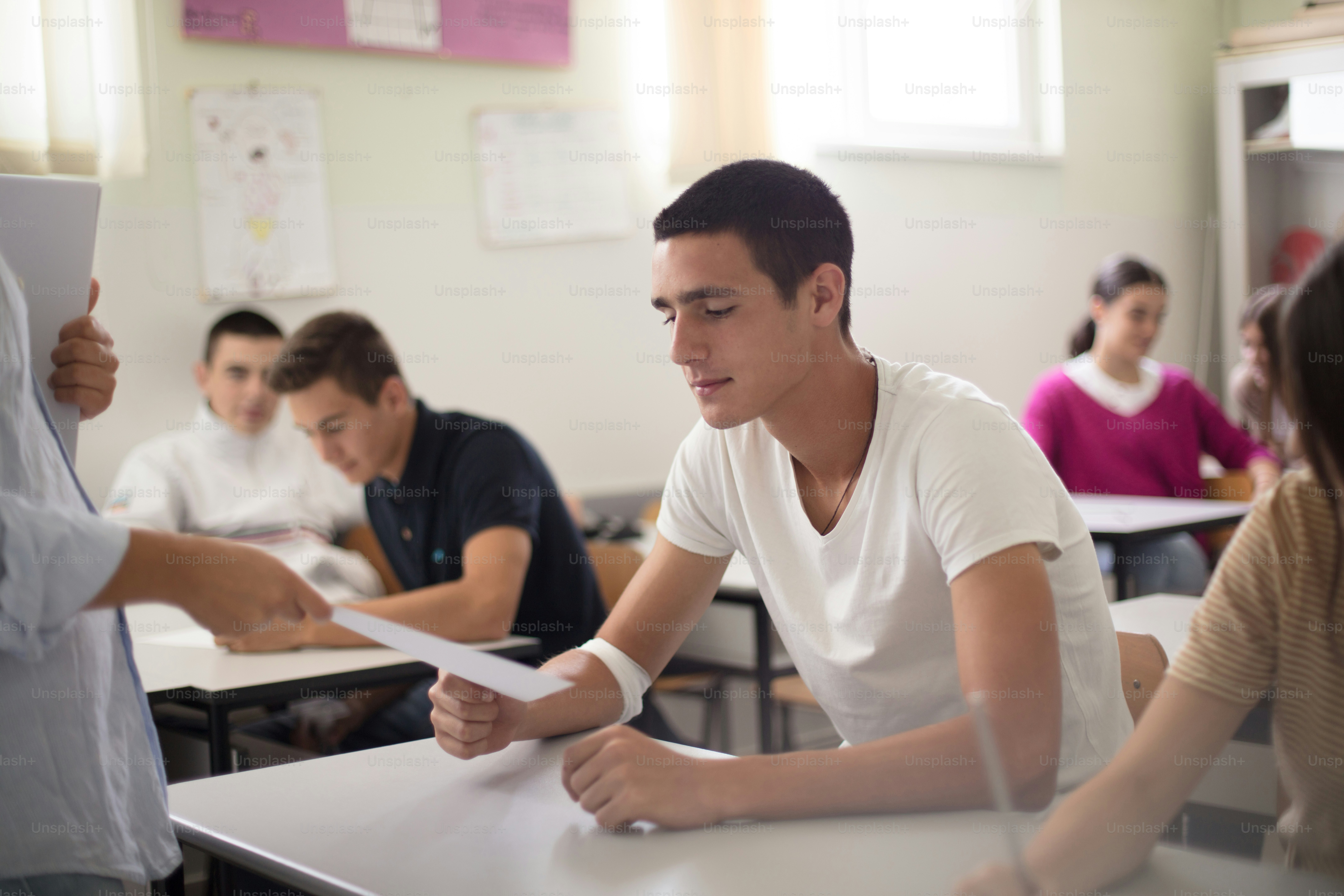 This grade is no good. Professor giving exam to his student. Focus is on background.