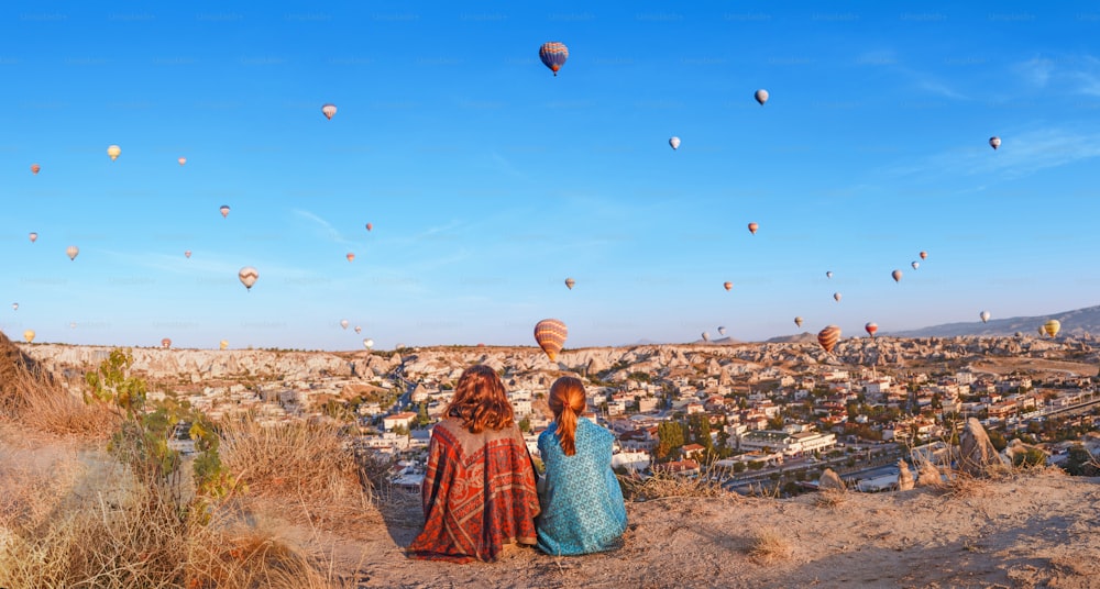 Coppia di amici viaggiatori che si godono la vista sulla valle con un meraviglioso volo in mongolfiera sulla valle della Cappadocia in Turchia
