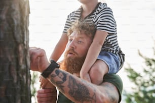 Happy childhood. Calm caucasian father holding at the shoulders his little daughter and spending time together. Father and child relationships concept. Stock photo