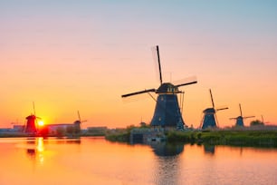 Netherlands rural lanscape with windmills at famous tourist site Kinderdijk in Holland on sunset with dramatic sky