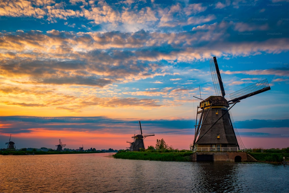 네덜란드의 유명한 관광지인 킨더다이크(Kinderdijk)의 풍차가 있는 네덜란드 시골 풍경, 극적인 하늘과 함께 일몰