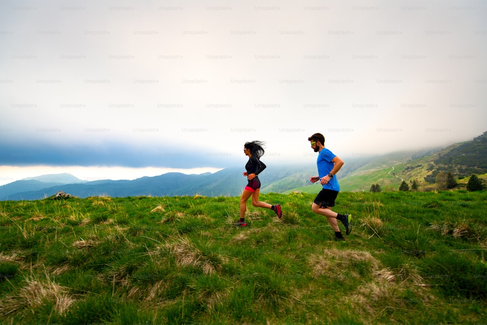 Entrenando para un par de atletas de trail running de larga distancia en la montaña