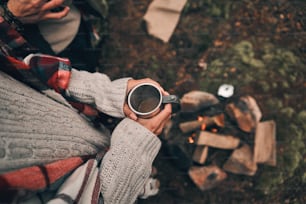 Close up top view of young couple resting while warming up near the campfire