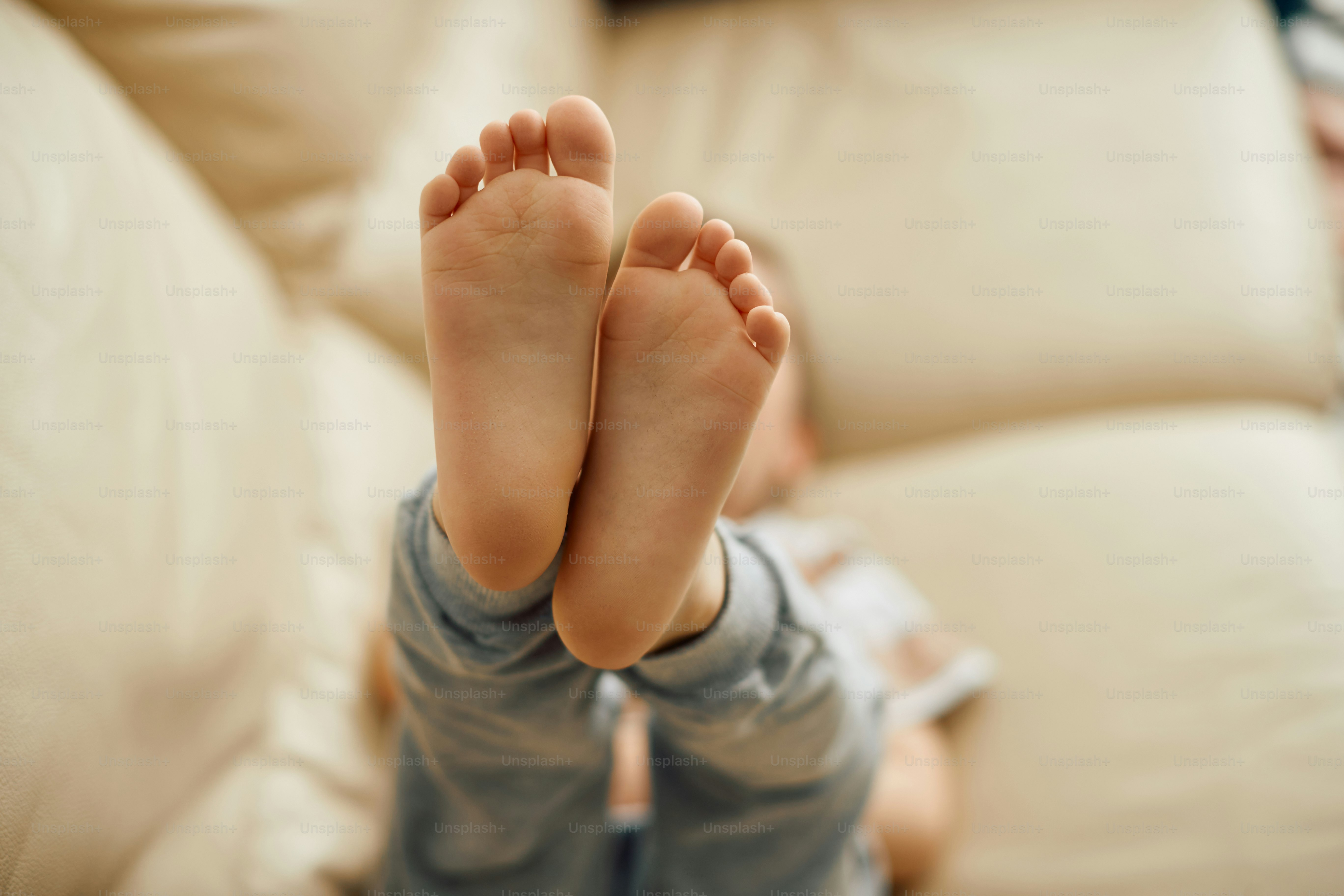 Closeup of little boy relaxing on the sofa wit his feet up. Focus is