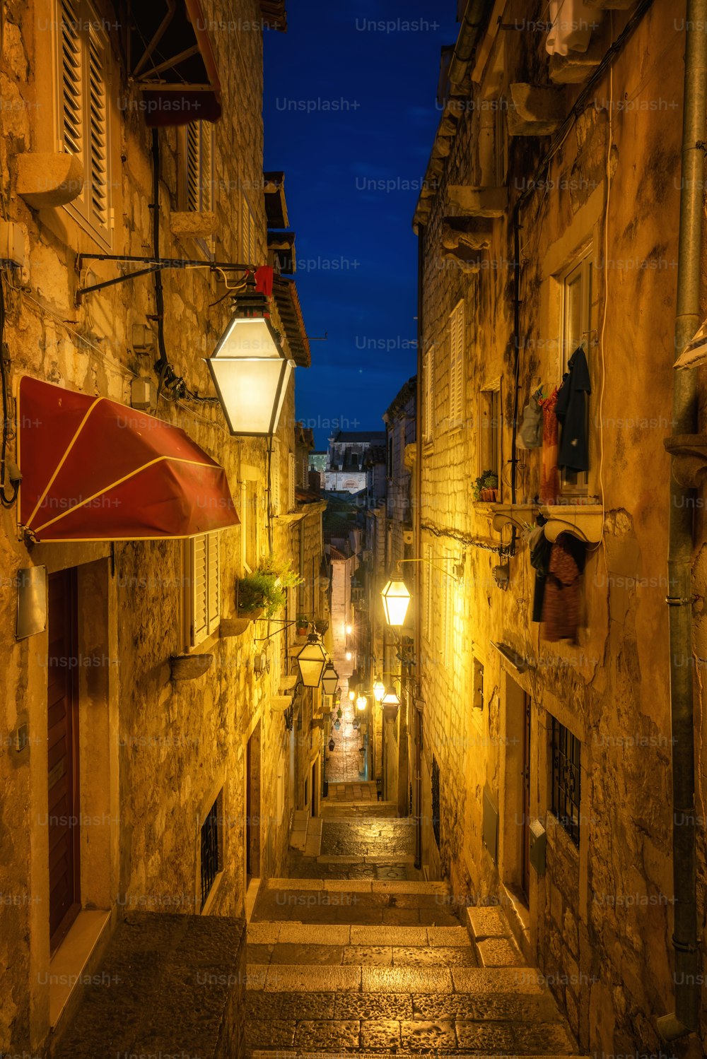 Célèbre ruelle étroite de la vieille ville de Dubrovnik en Croatie la nuit - Destination de voyage de premier plan de la Croatie. La vieille ville de Dubrovnik a été classée au patrimoine mondial de l’UNESCO en 1979.