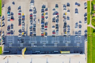 Aerial top down view of the parking lot with many cars of supermarket shoppers in the city grocery store