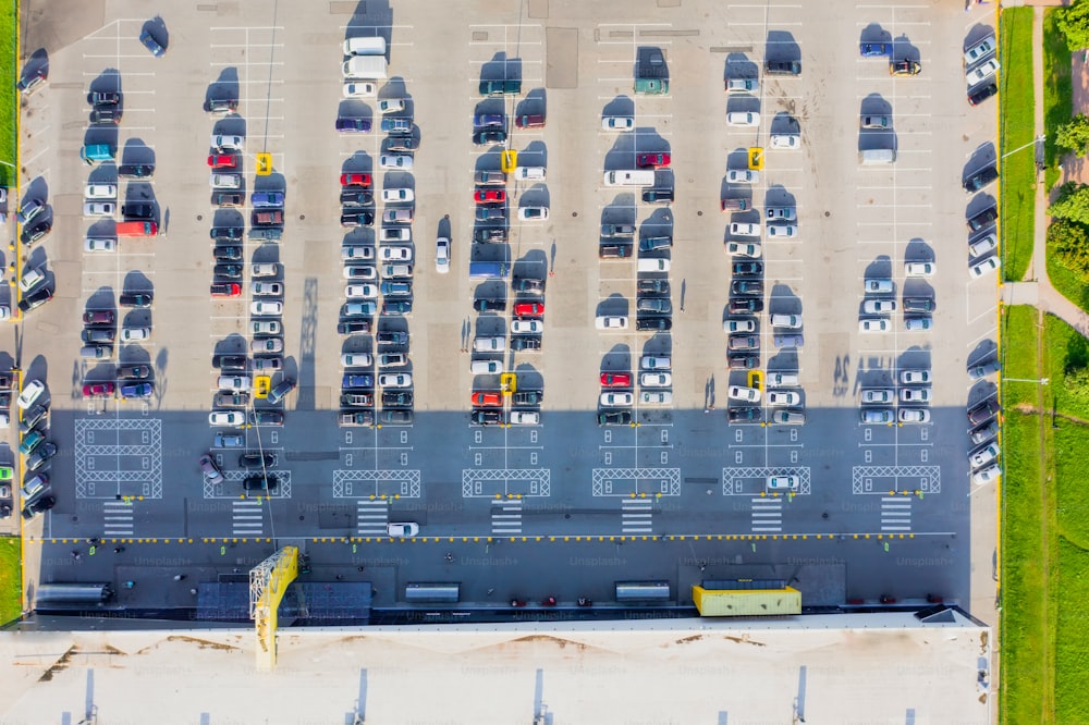 Aerial top down view of the parking lot with many cars of supermarket shoppers in the city grocery store