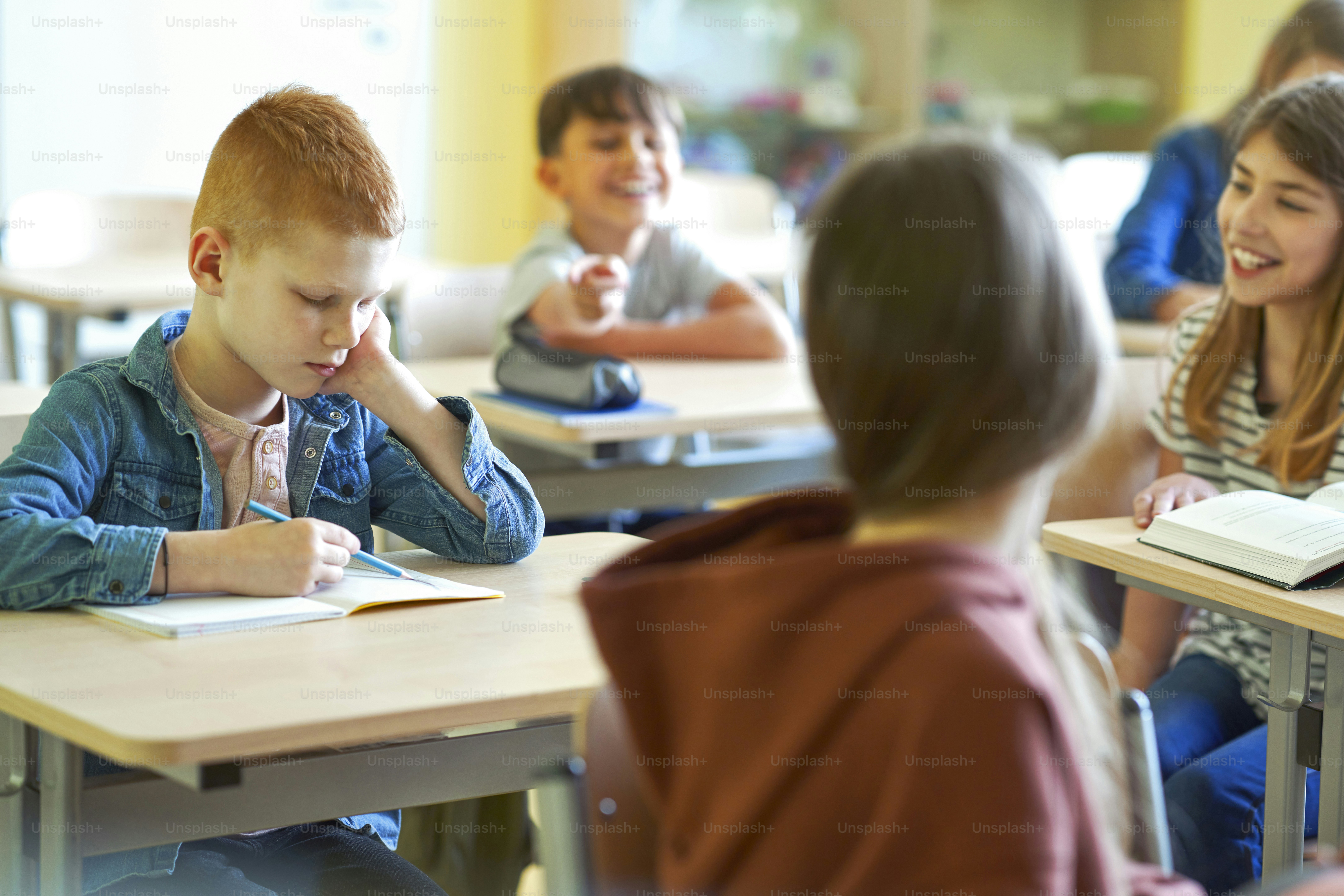 Sad schoolboy writing in note book photo – Book Image on Unsplash