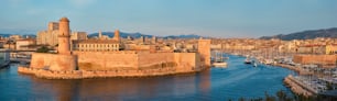 Yachts venant de la régate de bateaux vers le Vieux-Port de Marseille au coucher du soleil et le Fort Saint-Jean. Marseille, France