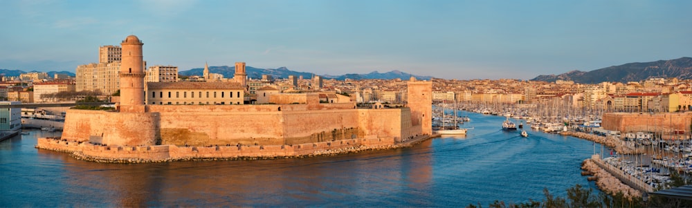 ボート レガッタから日没のマルセイユ旧港 (Vieux-Port de Marseille) とサン ジャン要塞に向かうヨット。マルセイユ、フランス
