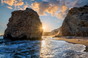 Praia de Fyriplaka e ondas do mar Egeu ao pôr do sol, ilha de Milos, Cíclades, Grécia