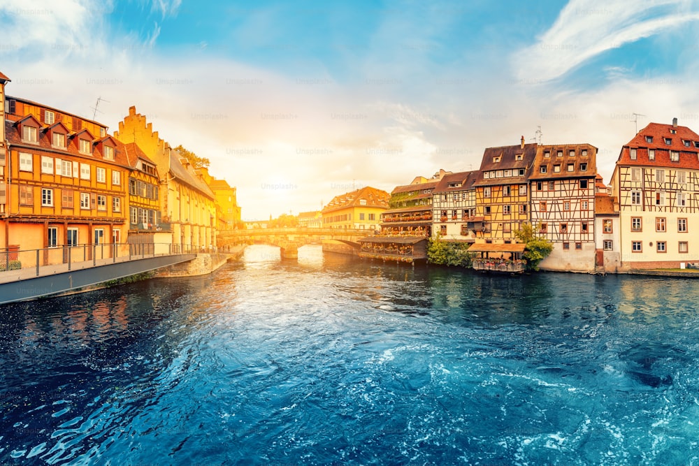 Colorful sunset in the region of Little France in the city of Strasbourg. Famous half-timbered houses, the river Ill and the bridge of St. Martin. Popular tourist destinations in Europe